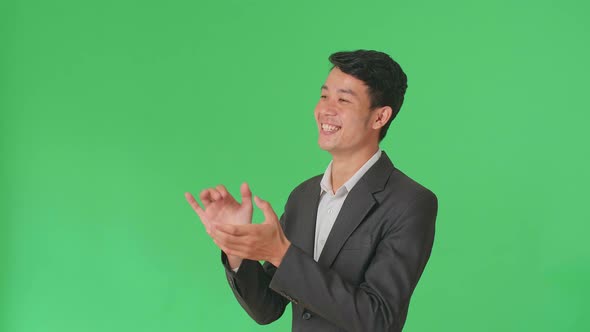 Side View Of Young Asian Business Man Clapping Her Hands In The Green Screen Studio alt