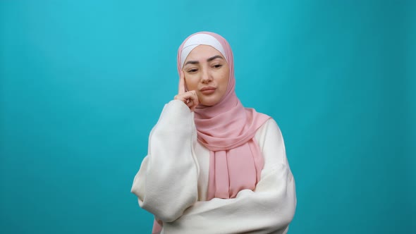 Young Muslim Woman in Hijab Thinking Pointing Finger Up and Having Great Idea Showing Thumbs Up