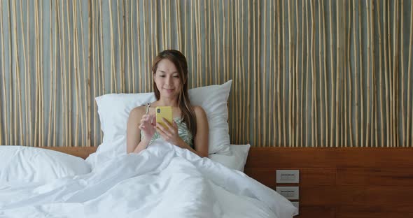 Woman use of smart phone on bed