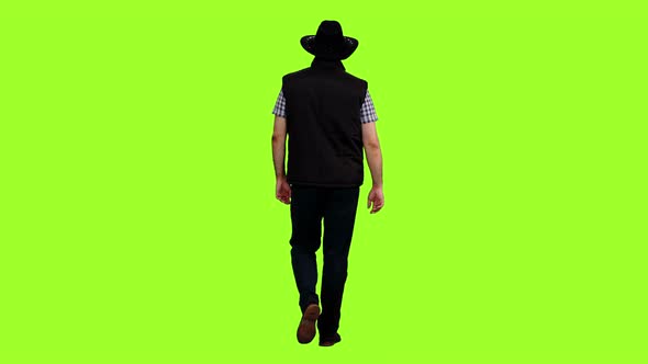 Back View of a Man Walking in a Black Vest and Cowboy Hat