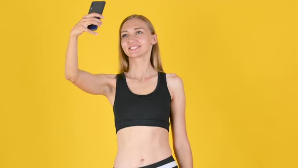 Smiling fit girl taking selfie after sports exercise
