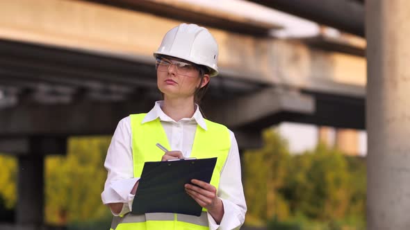 Young Female Builder in a Hard Hat at a Construction Site alt