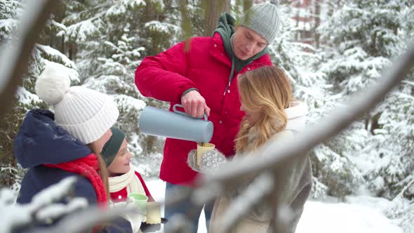 Family Basks with Hot Tea in the Winter Forest alt
