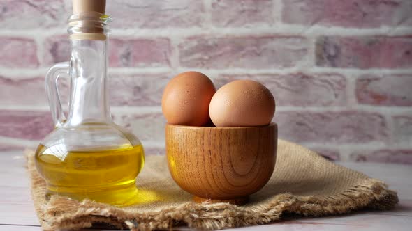 Top View of Eggs in a Bowl and Cooking Oil in a Jar alt