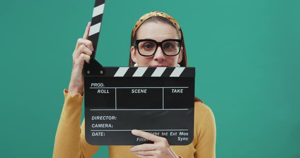 Funny sixties style woman with black clapper board. Isolated.