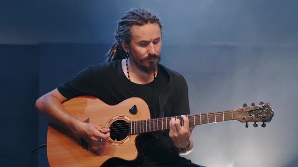 The Singer Plays an Acoustic Guitar at a Concert alt