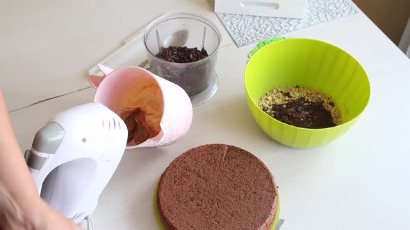 A Woman Makes Cream For A Chocolate Cake With Peanuts And Strawberries. alt