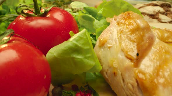 Close Up Savoury Grilled Chicken Breast with Fresh Tomatoes at the Kitchen Table alt
