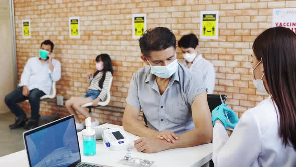 Coronavirus Vaccination.Doctor syringe injection to the young patient put on a mask alt