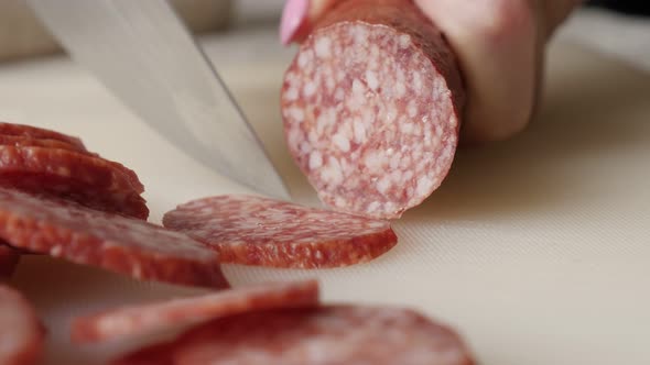 Using knife for smaller pieces cut of pork salami 4K 2160p 30fps UltraHD footage - Cutting cured sau