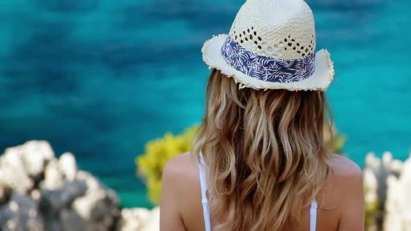 Woman looking at the sea standing at cliff