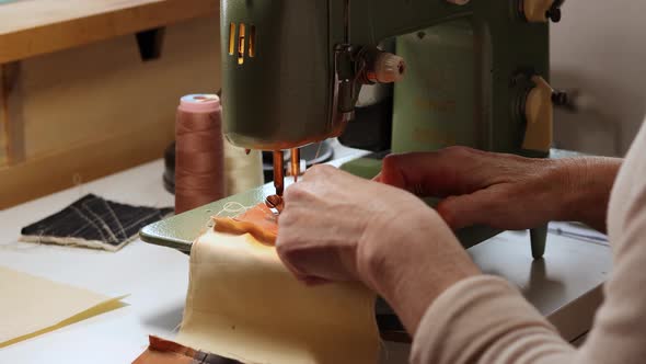 Closeup view of womans hands sewing fabric with a vintage, retro sewing machine.