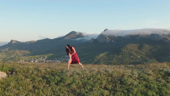 A View of a Woman Performing a Ritual Dance on a Hilltop in the Rays of Sunset Against a Background alt
