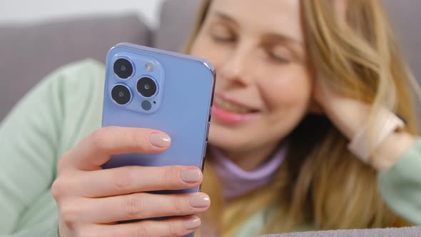 Happy female using modern smartphone for communication and entertainment online in 4k video alt