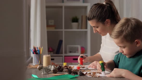 Mother and Son Making Pictures of Autumn Leaves alt