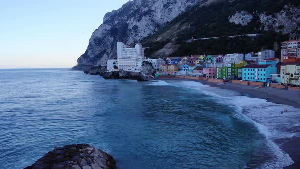 Colored Residential Buildings Of Catalan Bay Revealed Sea Walls In Gibraltar. Aerial Tilt-down Shot alt