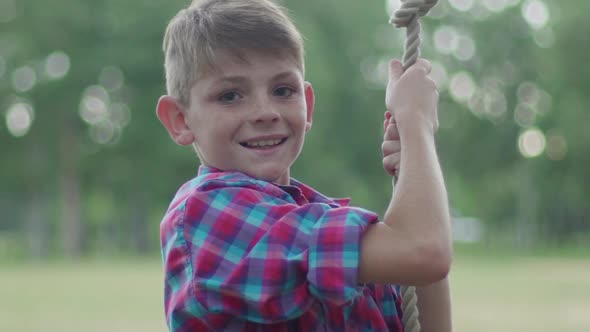 Boy swinging on rope outdoors