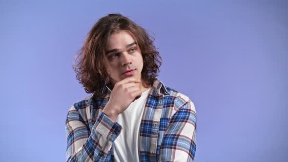 Young Thinking Pondering Man Having Idea Moment Pointing Finger Up on Violet Studio Background alt