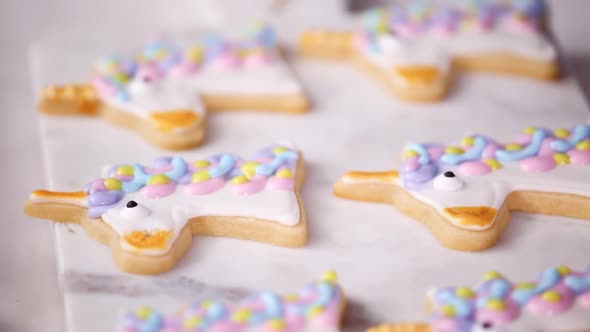 Step by step. Decorating unicorn shaped sugar cookies with royal icing for little girl birthday part alt