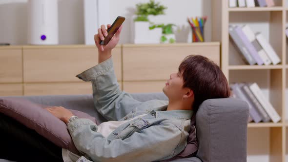 Asian guy contacts with friends through video call. Mobile distance virtual meeting alt