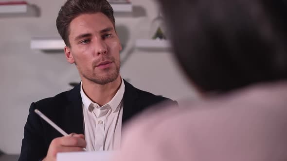 Businessman Has Interview with Woman Candidate at Table in Modern Office Spbi alt