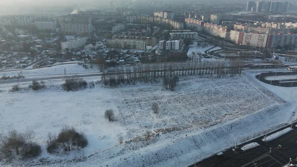 Flight over the city block. Winter cityscape. There is a railway line nearby. alt