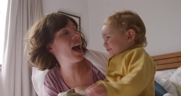 Caucasian woman with her baby at home in bedroom alt