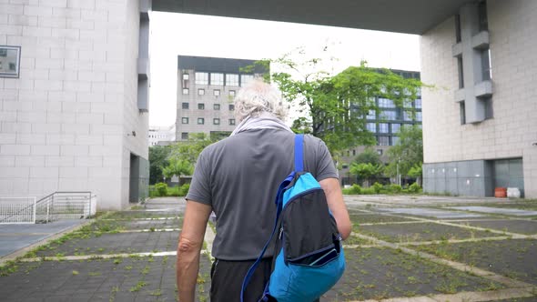 Slow motion shot of senior athletic man walking in city alt