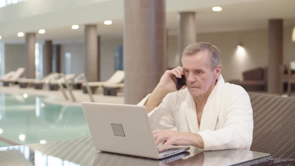 Old Businessman Having Phone Conversation in Swimming Pool alt