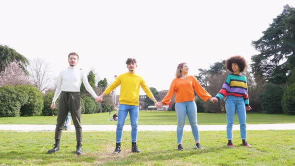 Slow motion group of four people friends jumping outdoor backlight excited alt