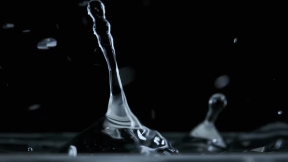 Many Drops of Water Fall on the Surface of the Water in Slow Motion Macro Shot alt