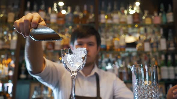 Bartender Pours Ice Into a Glass