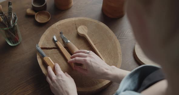 Close-up of Woman Carpenter's Hand Choosing Tools for Carving Wood alt