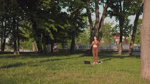 Woman working out using online video training outdoors
