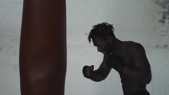Shirtless Boxer Punching the Heavy Bag Aggressively Shout with Anger alt