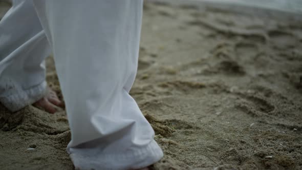 Man Feet Taking Steps on Sand Closeup alt