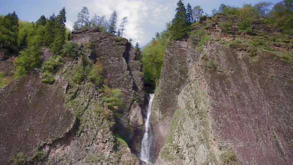 Waterfall between huge rocks alt