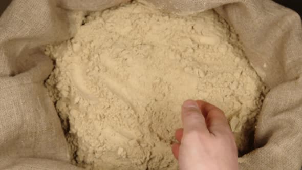 Human hand takes a pinch of a ginger powder in a sac
