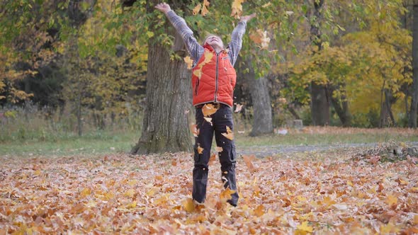 Autumn. Children Play with Fallen Leaves of Trees. alt