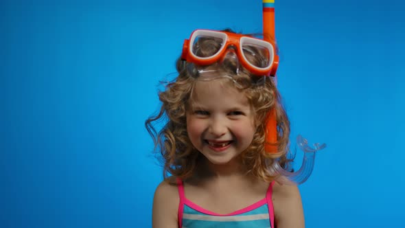 Cute Curly Girl with Swimming Mask and Snorkel is Laughing Happily in the Studio alt