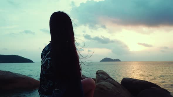 Cute Asian Girl Sitting on a Rock at Beautiful Sunset in Slow Motion Thailand
