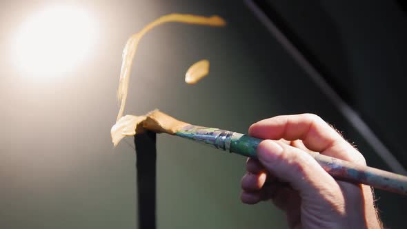 Slow motion: Low angle of man that drawing and painting with a brush and having fun. Street art conc alt