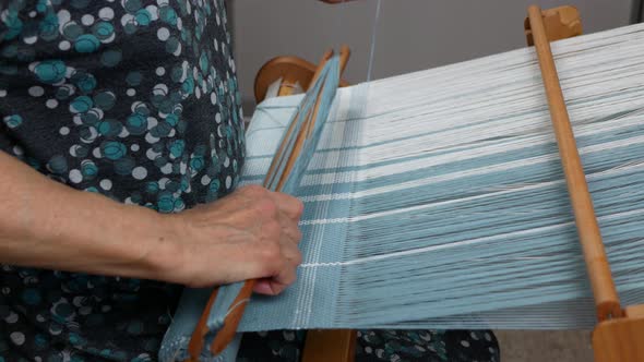 Hand loom weaving in action, side view