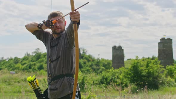 a Young Guy Shoots a Bow at a Target in Nature and Hits the Target the Arrow Pierces the Target for alt