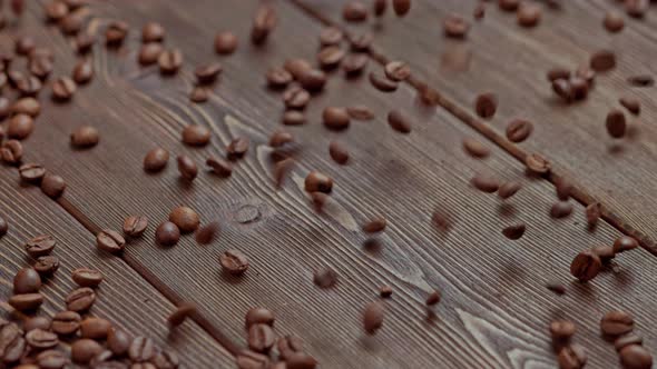 Roasted Brown Coffee Beans Falling on Wooden Board Surface
