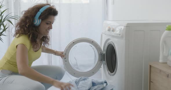 Happy young woman doing laundry at home