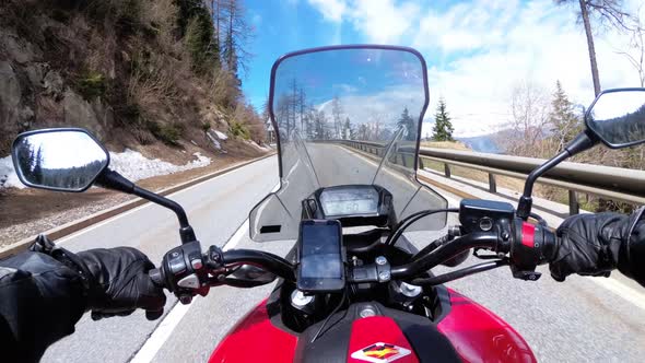 Motorcyclist Rides on Beautiful Landscape Mountain Road Near Snowy Switzerland Alps alt
