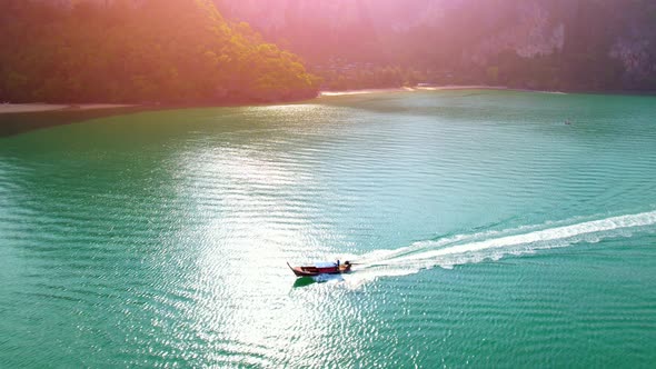 An aerial view of the boat sailing in the beautiful turquoise waters alt