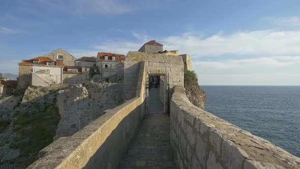 A gate on a stone wall by the sea alt