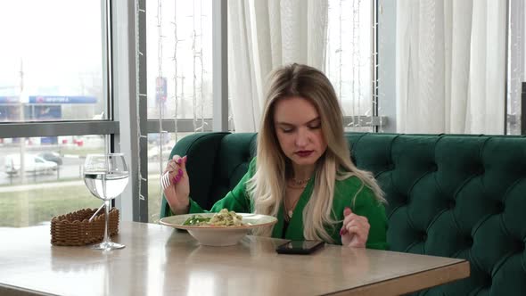 Blond Woman Eating Pasta with Appetite alt